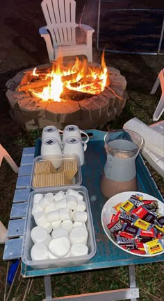 an outdoor fire pit with marshmallows and hot chocolate