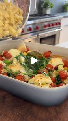 a casserole dish with tomatoes, spinach and cheese being tossed into it