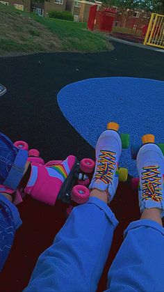 two feet on skateboards in front of a playground with play ground and children's toys