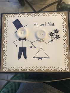 a couple of buttons sitting on top of a white and black card with the words mr and mrs