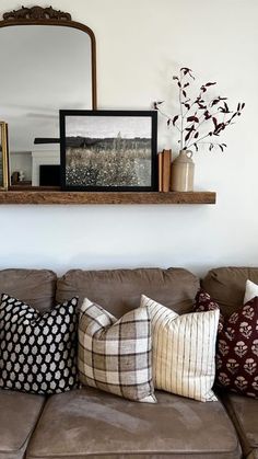 a living room with a brown couch and mirror