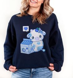 PLEASE NOTE:  This is a UNISEX sweater.  If you want an oversized look then consider ordering up a size. This cute blueberry milk cow sweater will look adorable on you!  Makes for a great kawaii gift for your loved ones as well. The collar is ribbed knit, so it retains its shape even after washing. There are no itchy side seams on these sweaters.  .: 50% cotton, 50% polyester .: Medium-heavy fabric (8.0 oz/yd² (271.25 g/m .: Loose fit .: Sewn-in label .: Runs true to size Kawaii Cotton Sweatshirt For School, Cotton Kawaii Sweatshirt For School, Blue Harajuku Cotton Sweatshirt, Blue Cotton Harajuku Sweatshirt, Cute Cotton School Sweater, Cute Cotton Sweater For School, Blue Harajuku Style Long Sleeve Sweatshirt, Blue Long Sleeve Harajuku Sweatshirt, Cute Cotton Sweater With Graphic Print