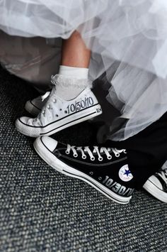 a bride and groom's feet in black converse shoes with white socks on their wedding day