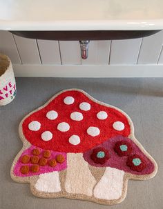 a red mushroom rug sitting on top of a bathroom floor