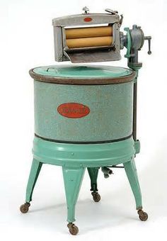 an old fashioned machine is sitting on top of a white surface with wheels and feet