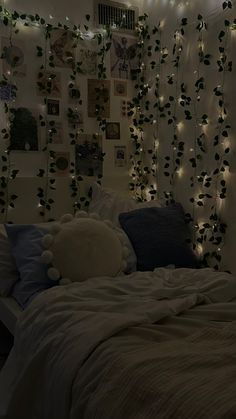 a bedroom decorated with lights and plants on the wall