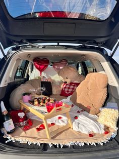 the trunk of a car filled with stuffed animals and other things to put in it