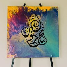 an arabic calligraphy is displayed on a easel