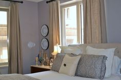 a bedroom with two clocks on the wall above the headboard and window sill