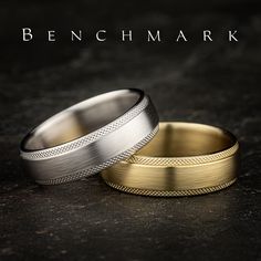 two gold and silver wedding bands sitting on top of a black surface with the words benchmark written above them