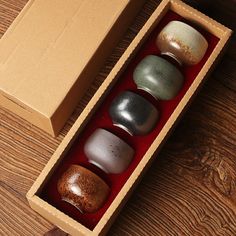 an open box with six different colored rocks in it