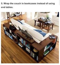 a couch sitting on top of a wooden floor next to a book shelf filled with books