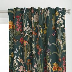 a green curtain with colorful flowers and plants printed on the outside, hanging from a metal rod