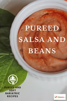 a white bowl filled with sauce on top of a green leaf