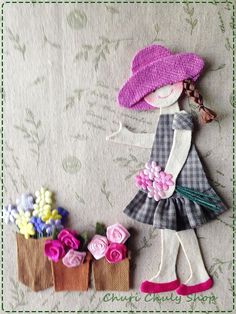 a doll with flowers in her hand next to some small purses on a table