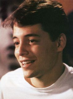 a close up of a person wearing a white t - shirt and looking at the camera