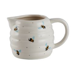 a white ceramic pitcher with bees on it