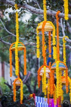 an assortment of colorful decorations hanging from a tree