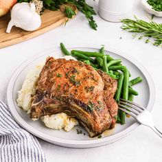 a white plate topped with meat and green beans