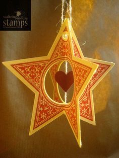 a star ornament with a heart hanging from it's side on a string