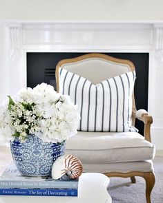 a blue and white vase filled with flowers on top of books