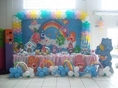 there is a table with balloons and teddy bears on it in front of a wall