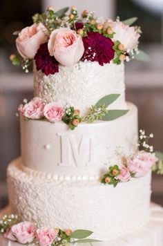 a wedding cake decorated with flowers and greenery