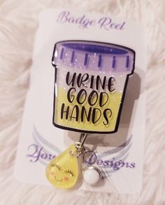 a badge with the words urine good hands and a yellow tear dropper attached to it