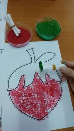 a child's hand holding a paintbrush and drawing on paper