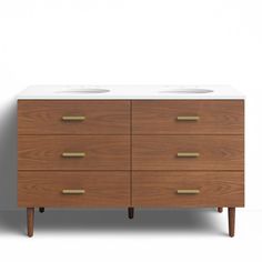 two sinks on top of a wooden dresser with white counter tops and brass handles, against a plain background