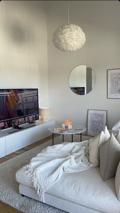 a living room filled with furniture and a flat screen tv on top of a wall