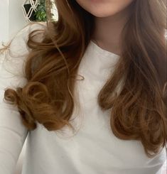 a woman with long brown hair is taking a selfie