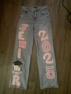 the hello kitty jeans have been painted with pink and white letters on them, which are also