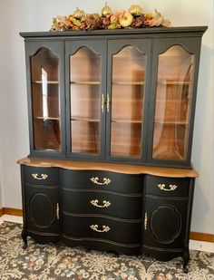 a black china cabinet with glass doors and drawers