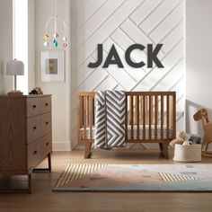 a baby's room with a wooden crib, dresser and toy horse on the floor