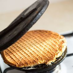 a waffle iron on top of a stove with some kind of food cooking in it