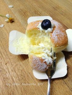 a piece of bread with blueberries and cream on it is being eaten by a fork