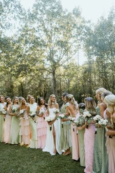 a group of women standing next to each other on top of a lush green field