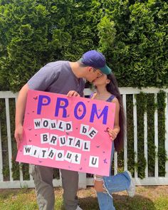 a man kissing a woman holding a sign that says prom would be bridal without u