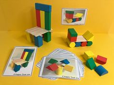 several pieces of construction paper are arranged on a yellow surface, including blocks and magnets