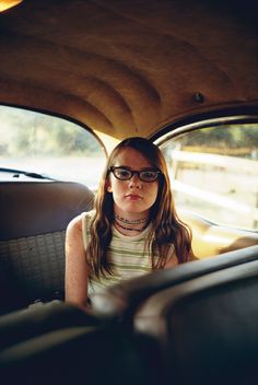 a woman sitting in the back seat of a car