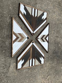 three pieces of wood are arranged in the shape of an arrow on concrete flooring