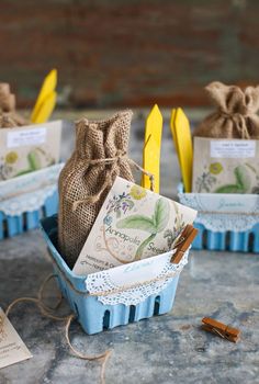 three small baskets filled with different types of paper and twine on top of a table