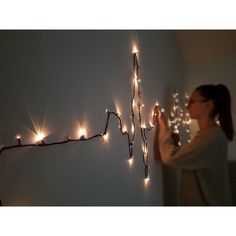 a woman standing in front of a string of lights that spell out the word love