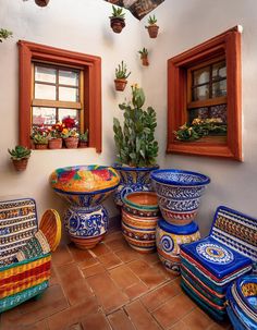 a room filled with lots of colorful vases and planters on the floor next to each other