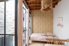 two beds in a room with wooden ceiling and wallpaper on the walls next to each other