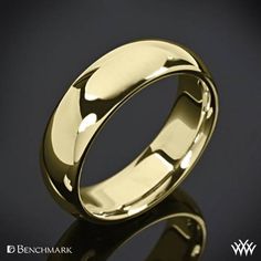 a gold wedding ring on a black background