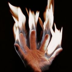 a person's hand is shown with white and orange flames coming out of it