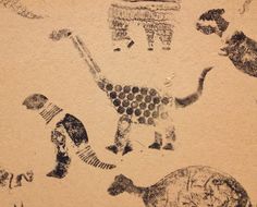 an image of some animals and people on the ground in black ink with brown paper