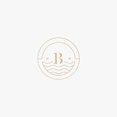 the letter b is inscribed in gold on a white background with an ocean wave and waves